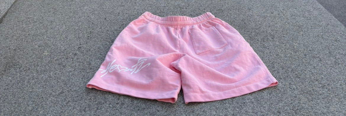 Pink shorts on a city street with buildings in the background